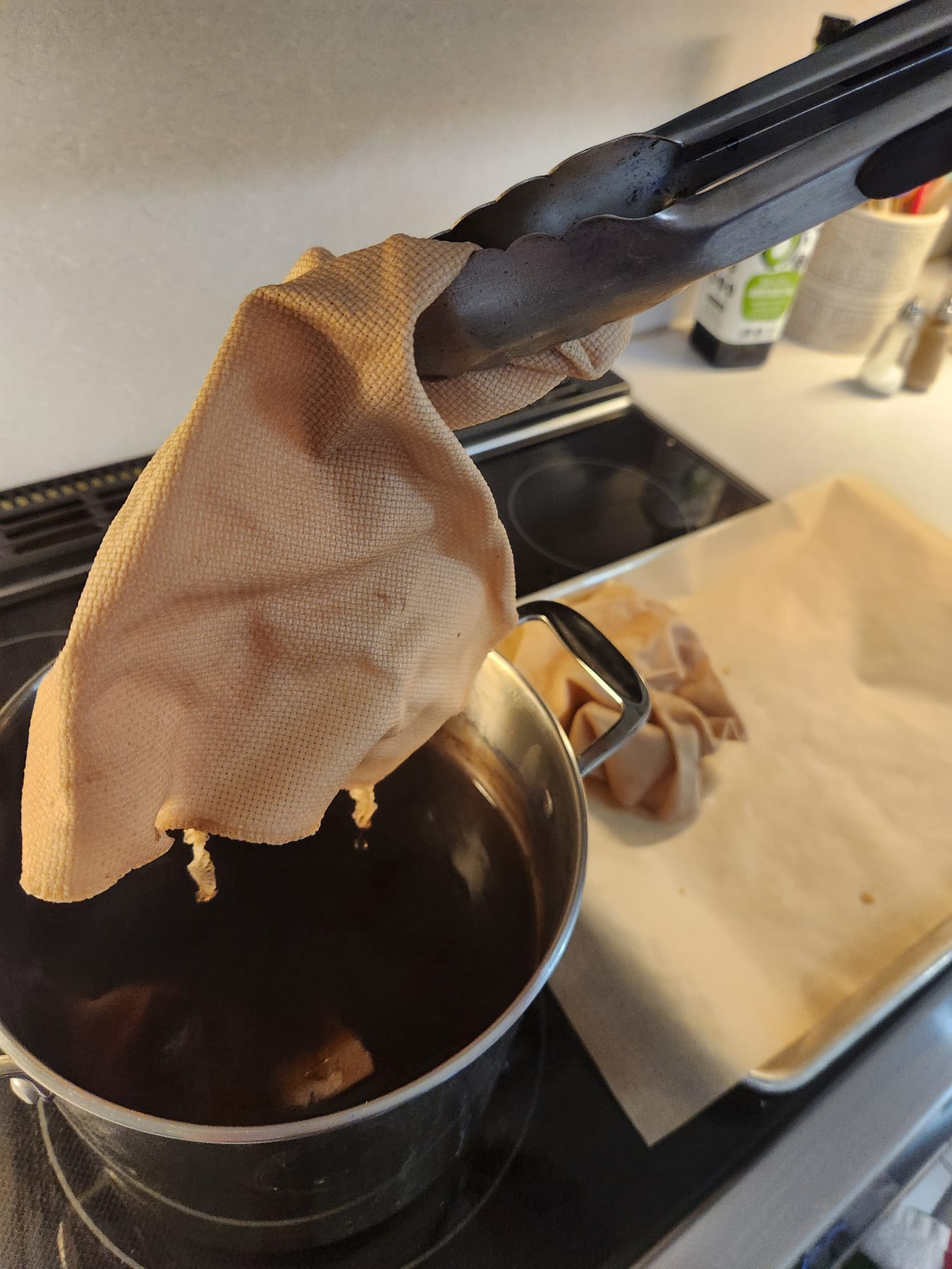 Dyed fabric dripping over the pot before transferring to the baking sheet