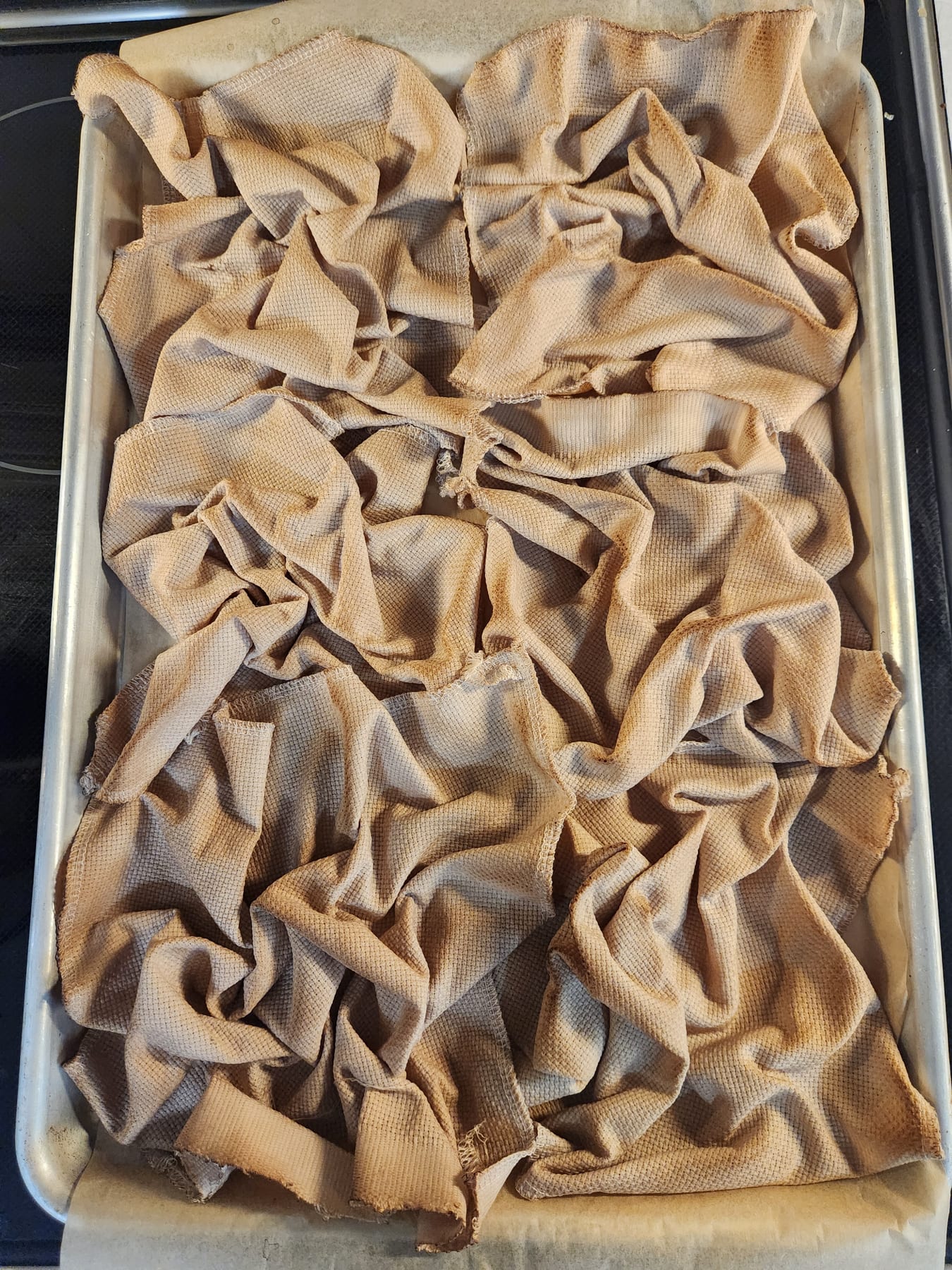 The baked fabric showing its mottled tea-stained pattern on the tray