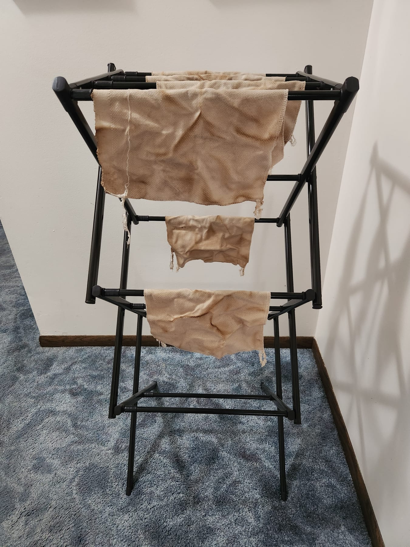 Dyed fabric pieces hung over a rack to finish drying