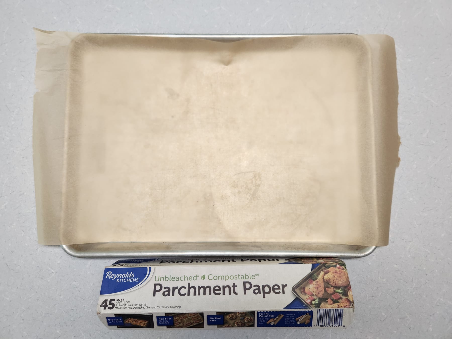 Empty baking sheet lined with parchment paper, ready for the fabric