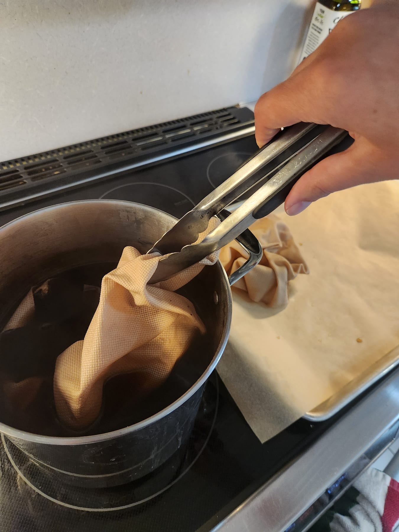 Lifting the dyed fabric out of the pot with tongs