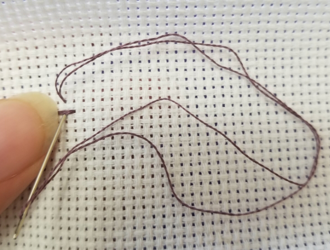 Holding the loose ends to the left on the back of the fabric